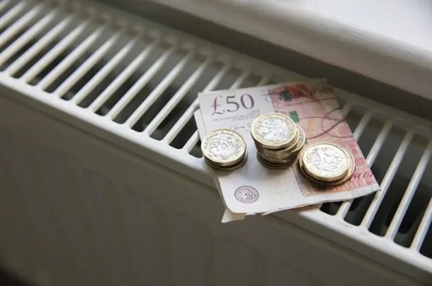 Money on a radiator, a £50 pounds and some £1 and £2 coins